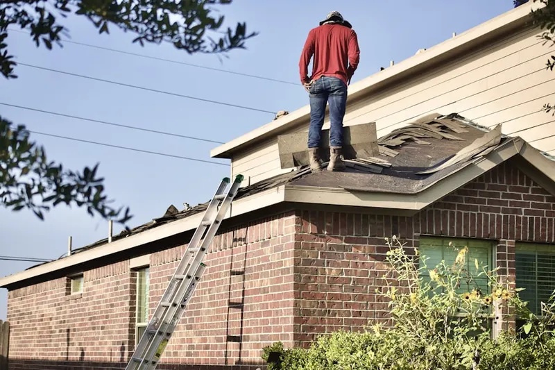 Professional roofer working on a residential roof in Belvoir Manor